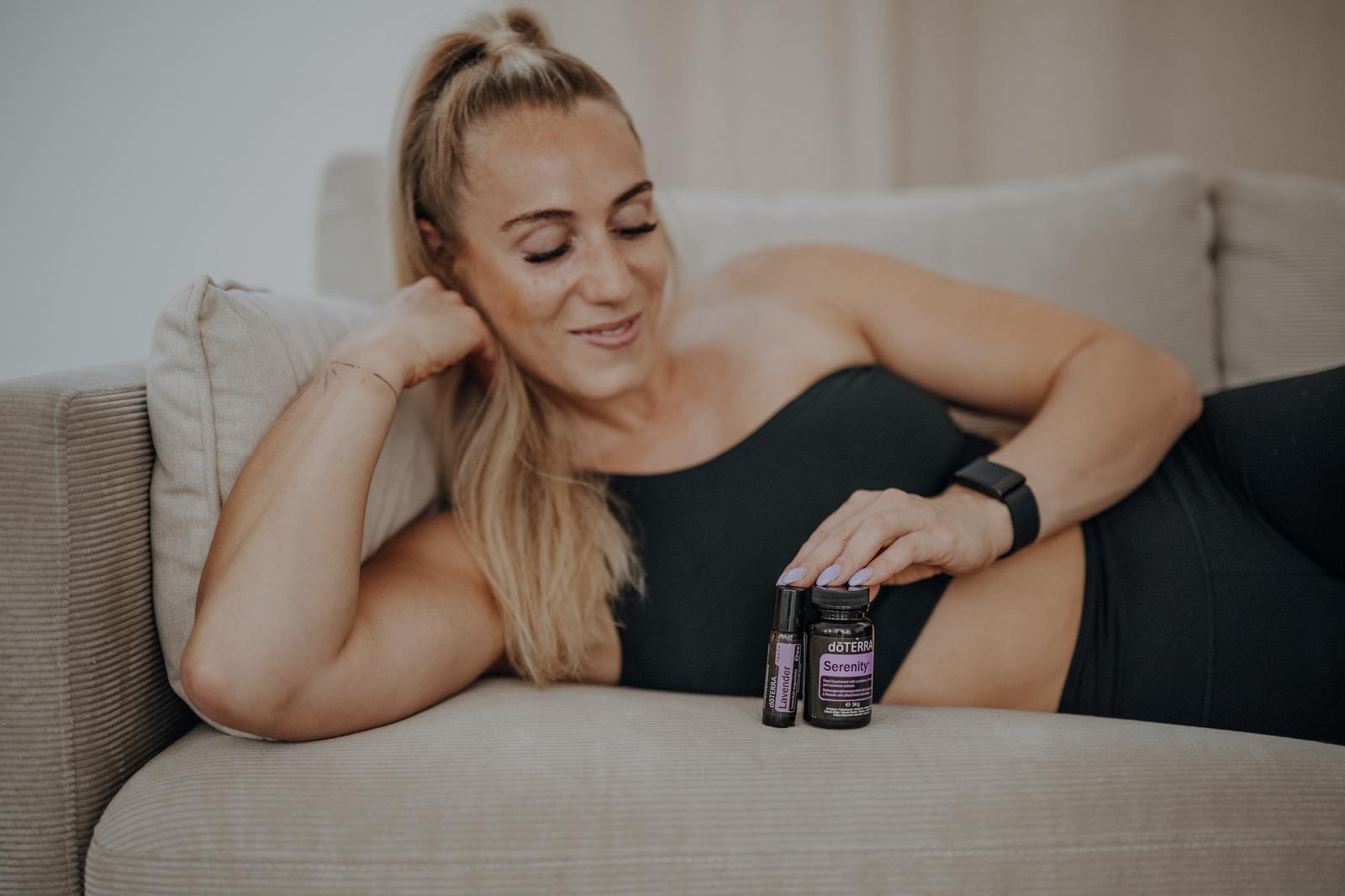 Anki Strahl liegt lachend auf dem Sofa, daneben zwei Ölfläschchen