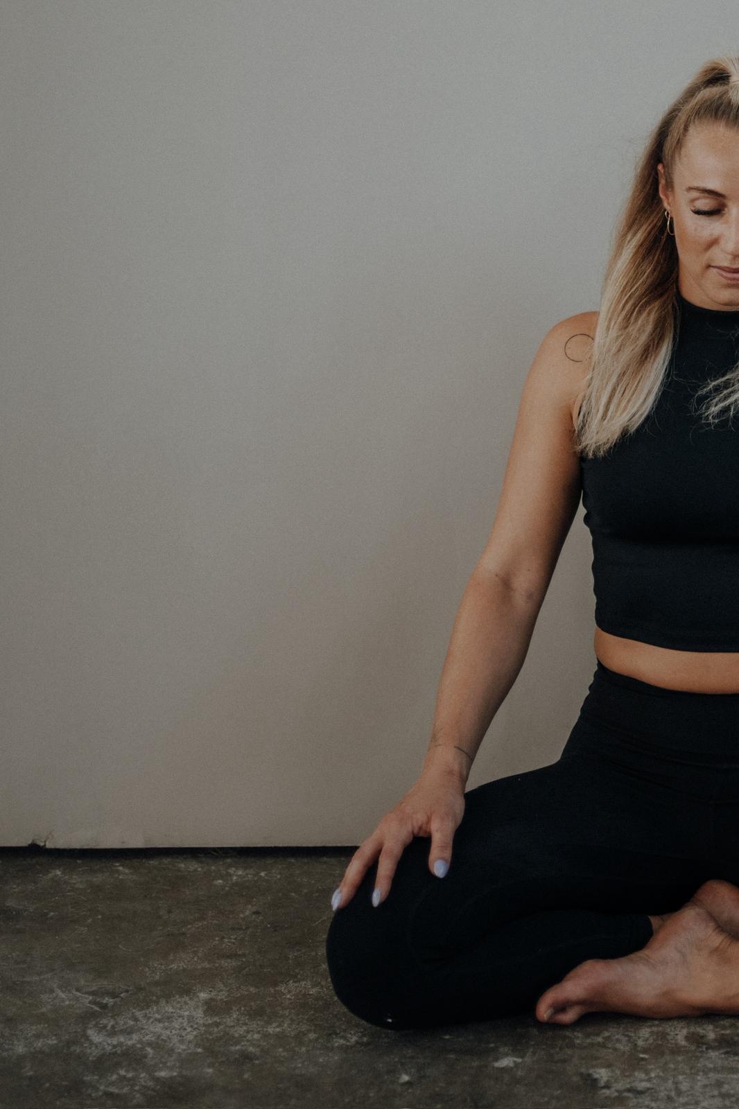 Yogalehrerin Anki Strahl sitzt mit geschlossenen Augen im Schneidersitz auf dem Boden