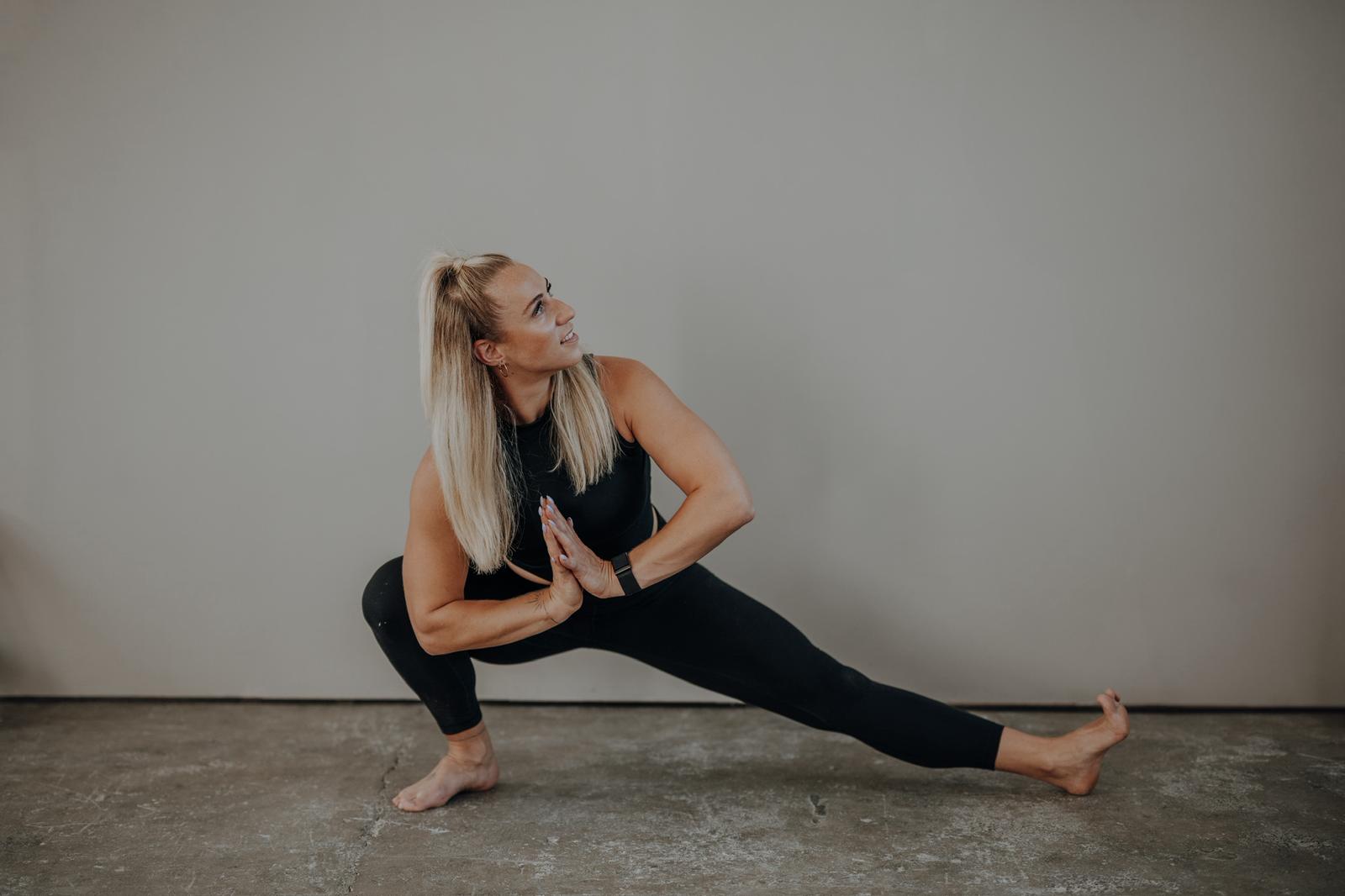 Vinyasa Yoga: Anki Strahl im tiefen Ausfallschritt, die Hände vor dem Herzen